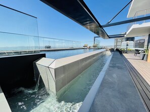Una piscina al aire libre, sillones reclinables de piscina