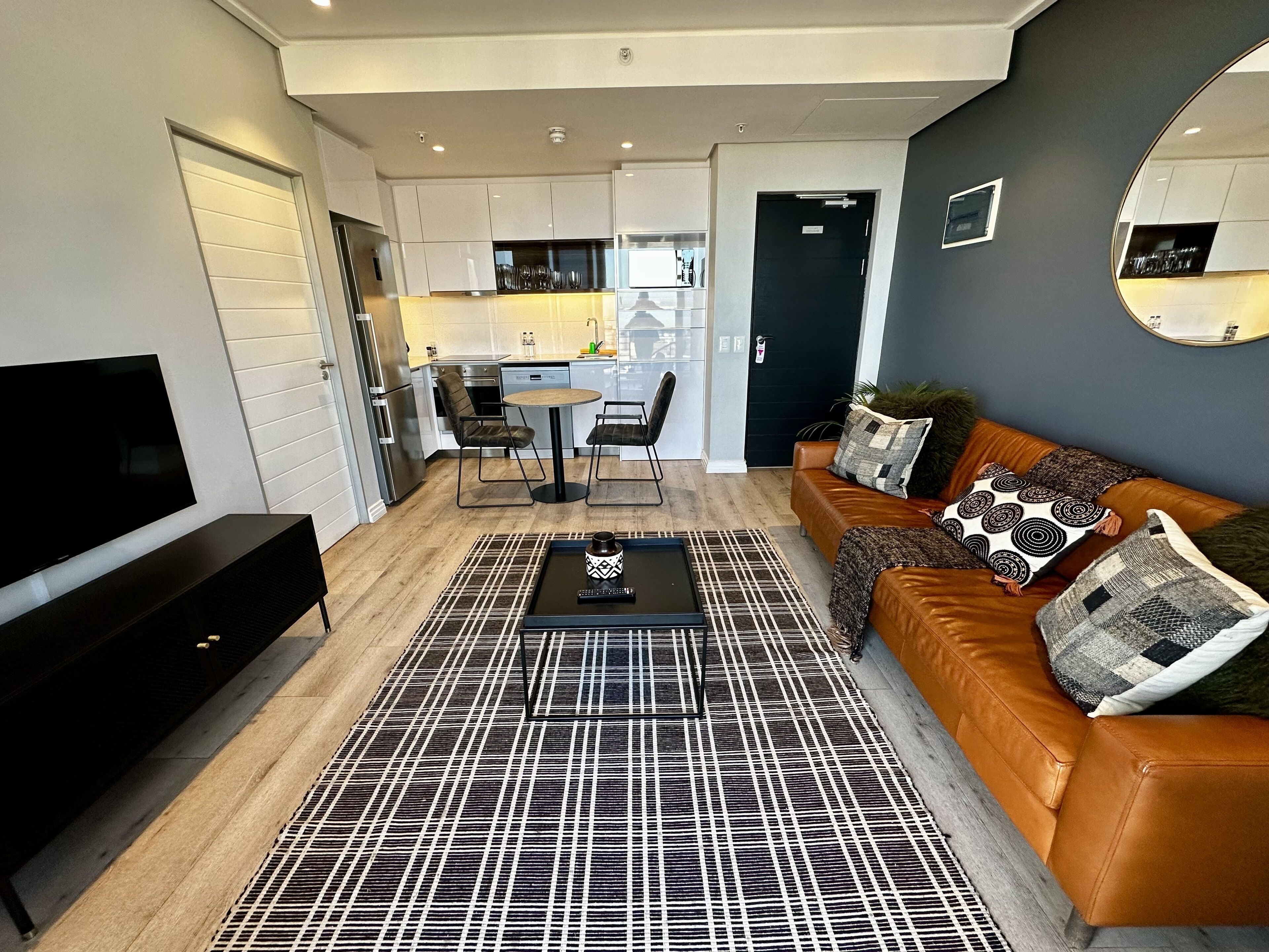 A modern apartment with a living room, dining area, and kitchen.
