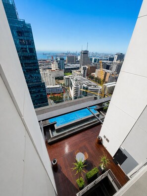 A rooftop pool with a city view, a wooden deck, and a small seating area. - Urban Elephant 16 on Bree (Cape Town)