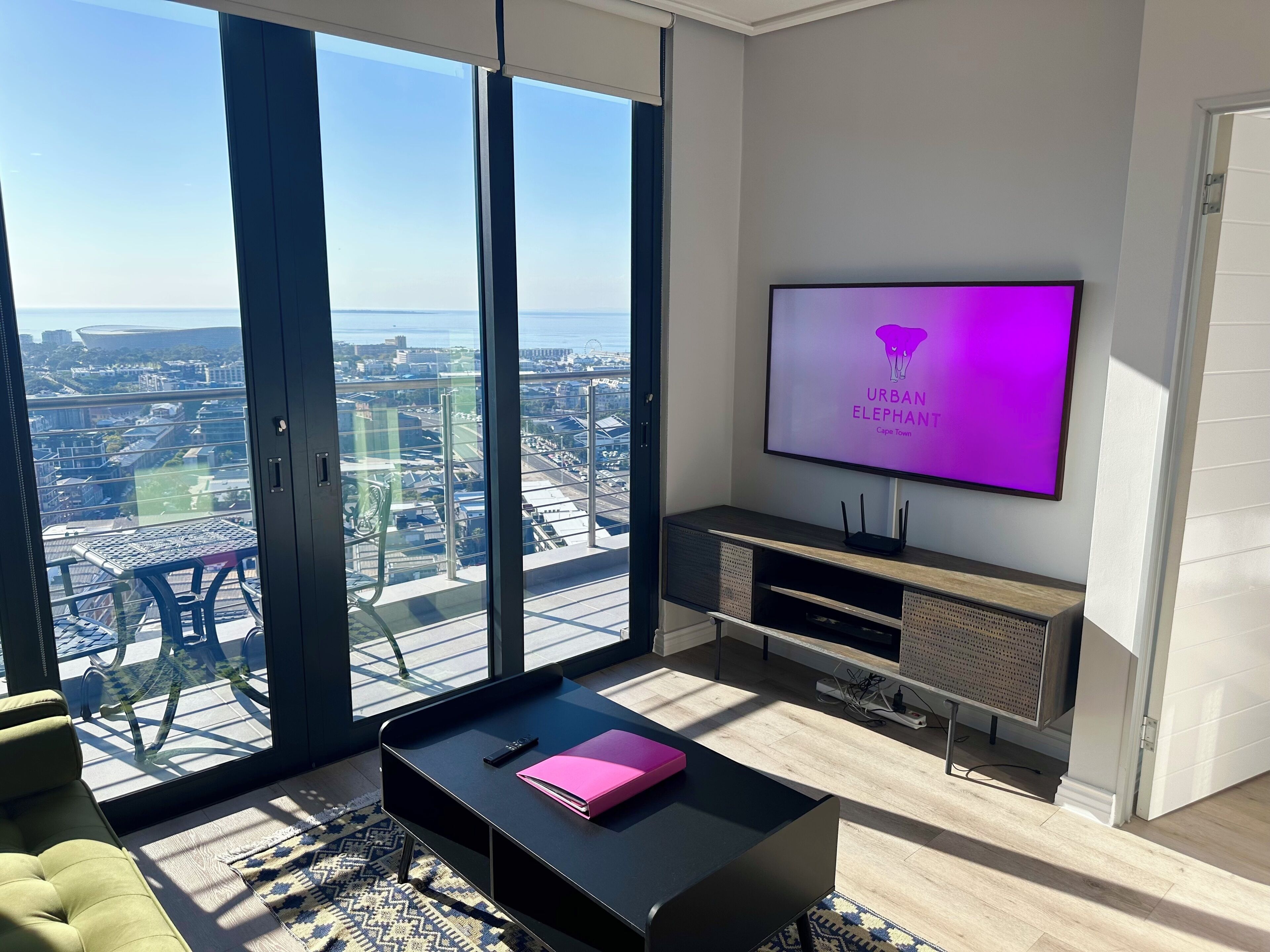 Una sala de estar moderna con un televisor grande, un sofá y una mesa de centro.