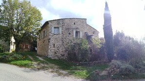 A stone building with a round shape, a tall tree in front, and a stone wall to the right. - Logement Entier Avec Terrasse et vue Panoramique (Francillon-sur-Roubion)