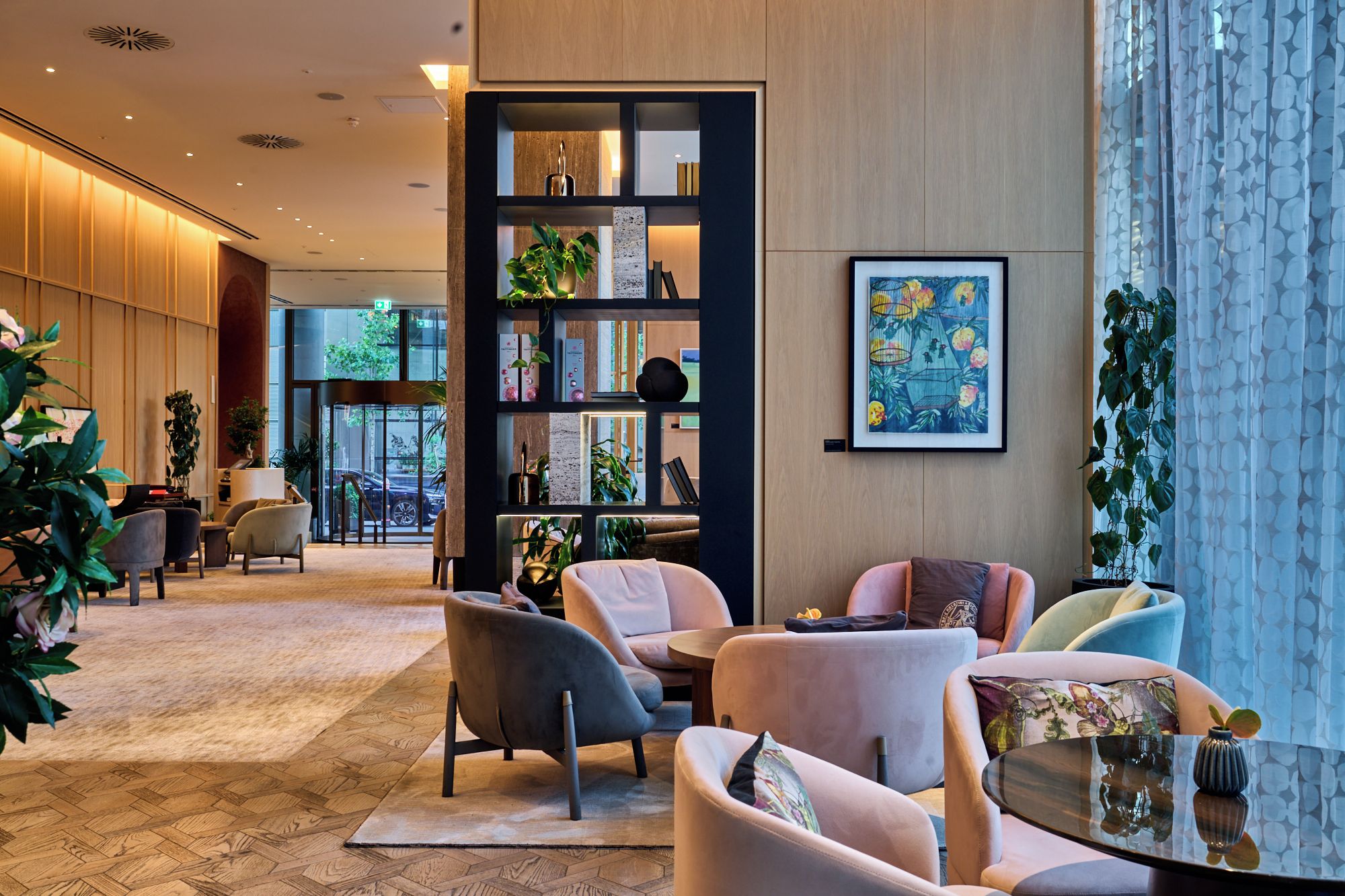 A modern lobby with seating, a bookshelf, and artwork.