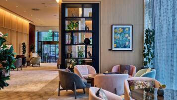 A modern lobby with seating, a bookshelf, and artwork.
