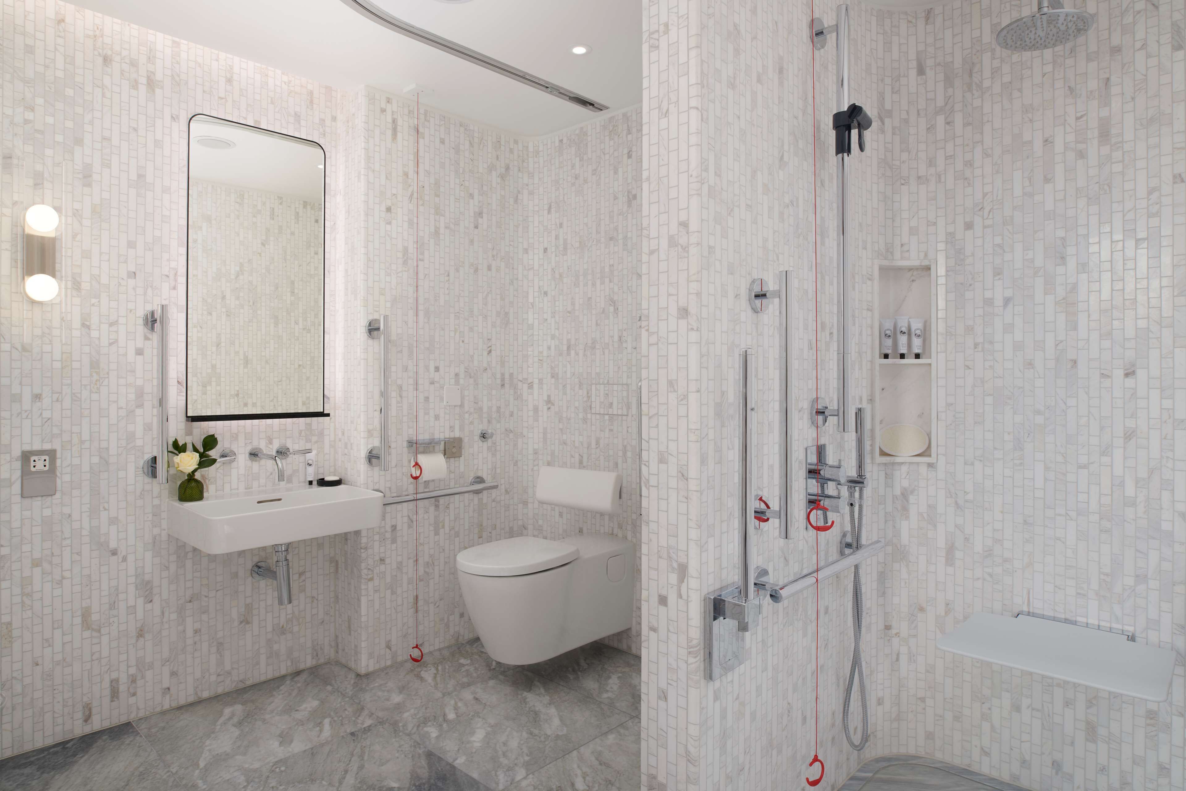 A modern bathroom with a white sink, toilet, and shower.