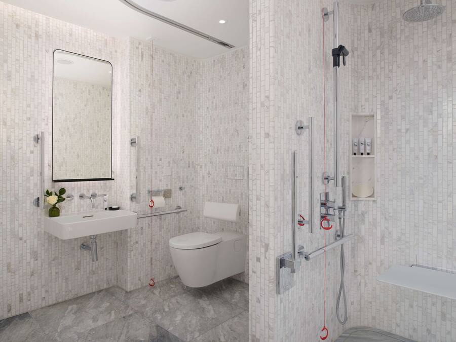 A modern bathroom with a white sink, toilet, and shower.