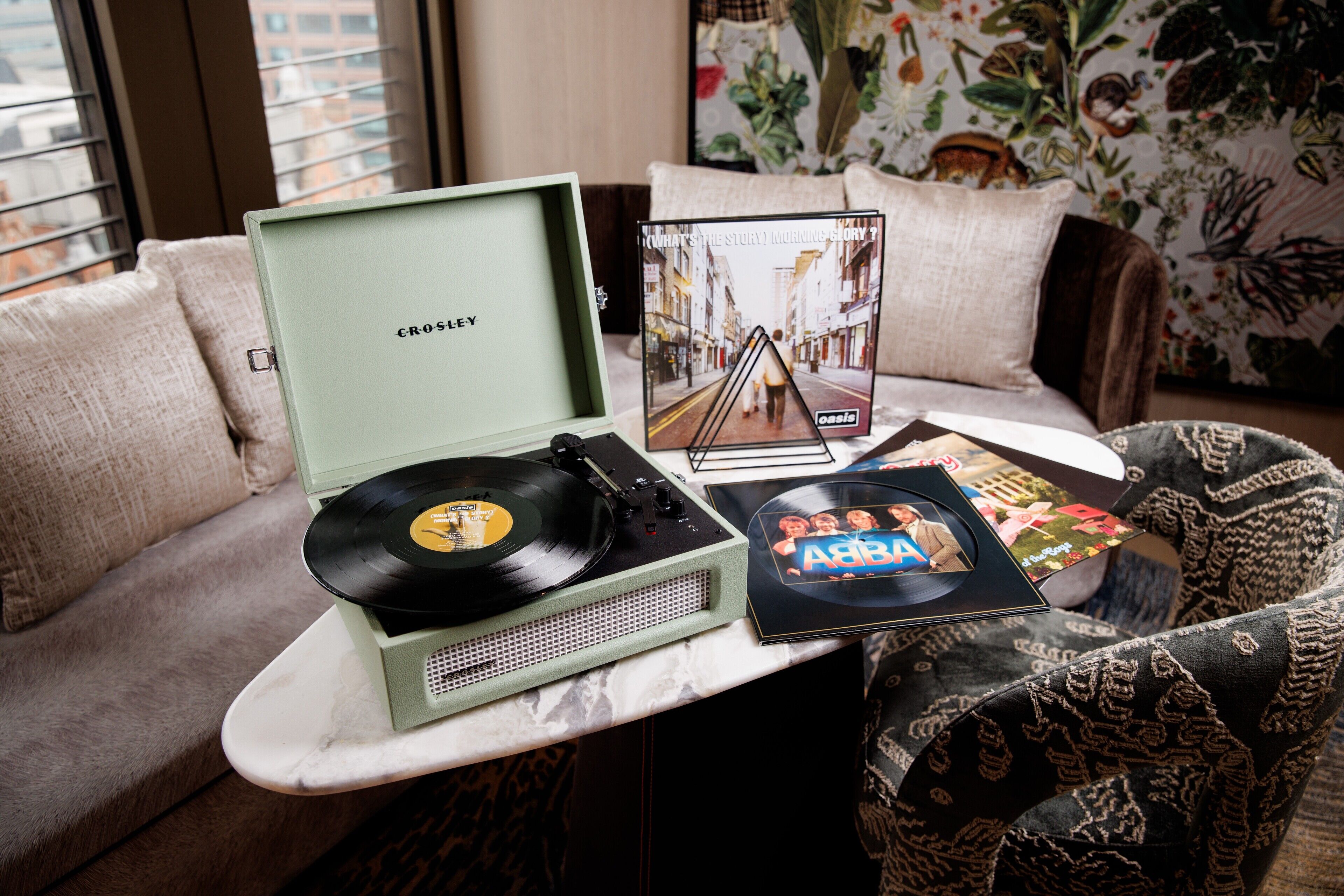 A cozy living room with a vinyl record player, a CD, and a book on a coffee table.