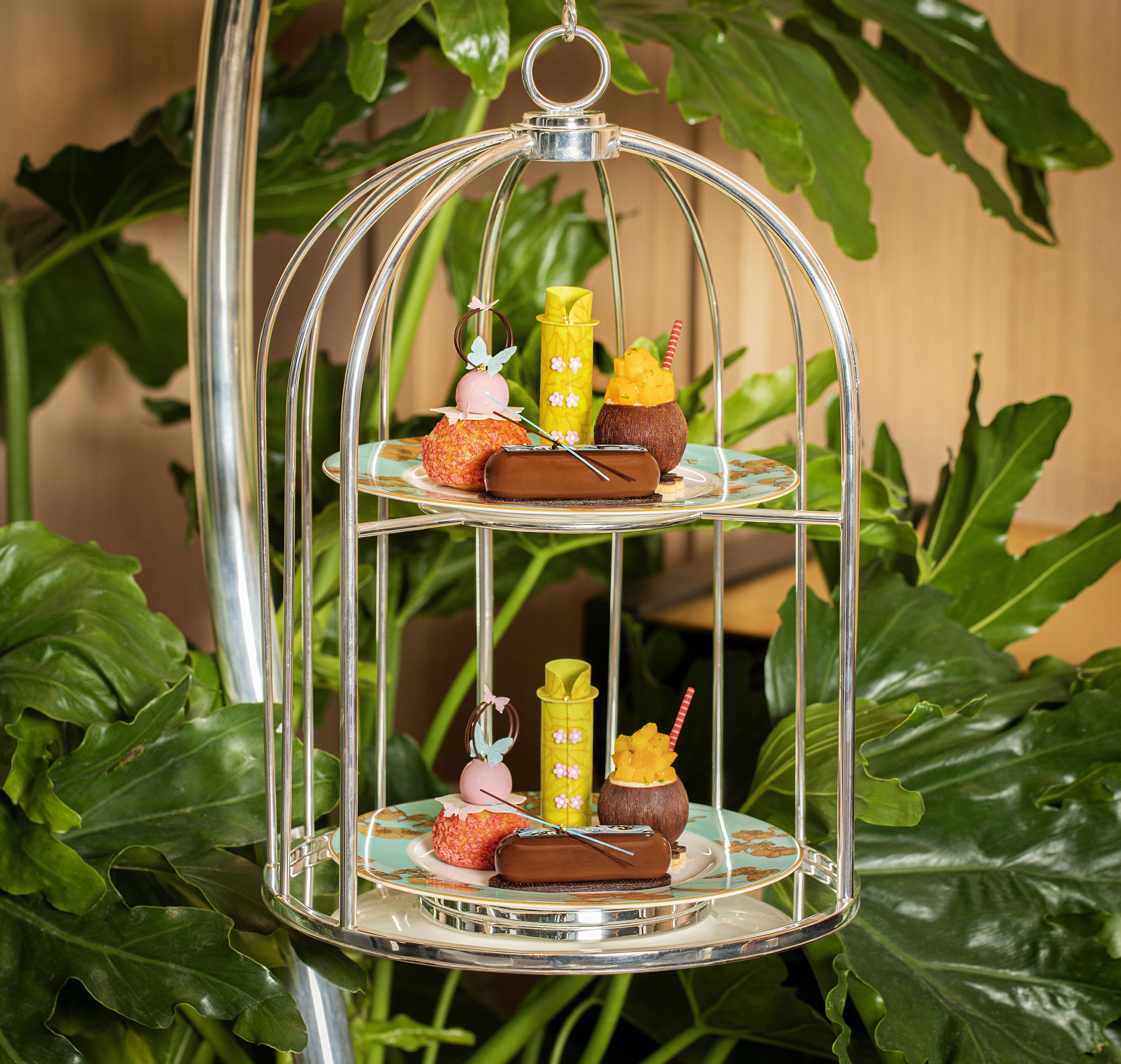 Un soporte metálico de tres niveles con diversos alimentos y bebidas.