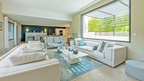 A modern living room with a large window, a sofa set, and a coffee table.