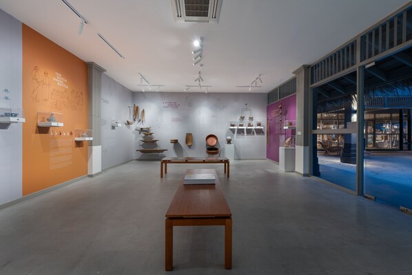 An interior with a long wooden table, white walls, and various displayed artifacts. - Cora Cora Maldives-Premium All-Inclusive (Maamigili Island)