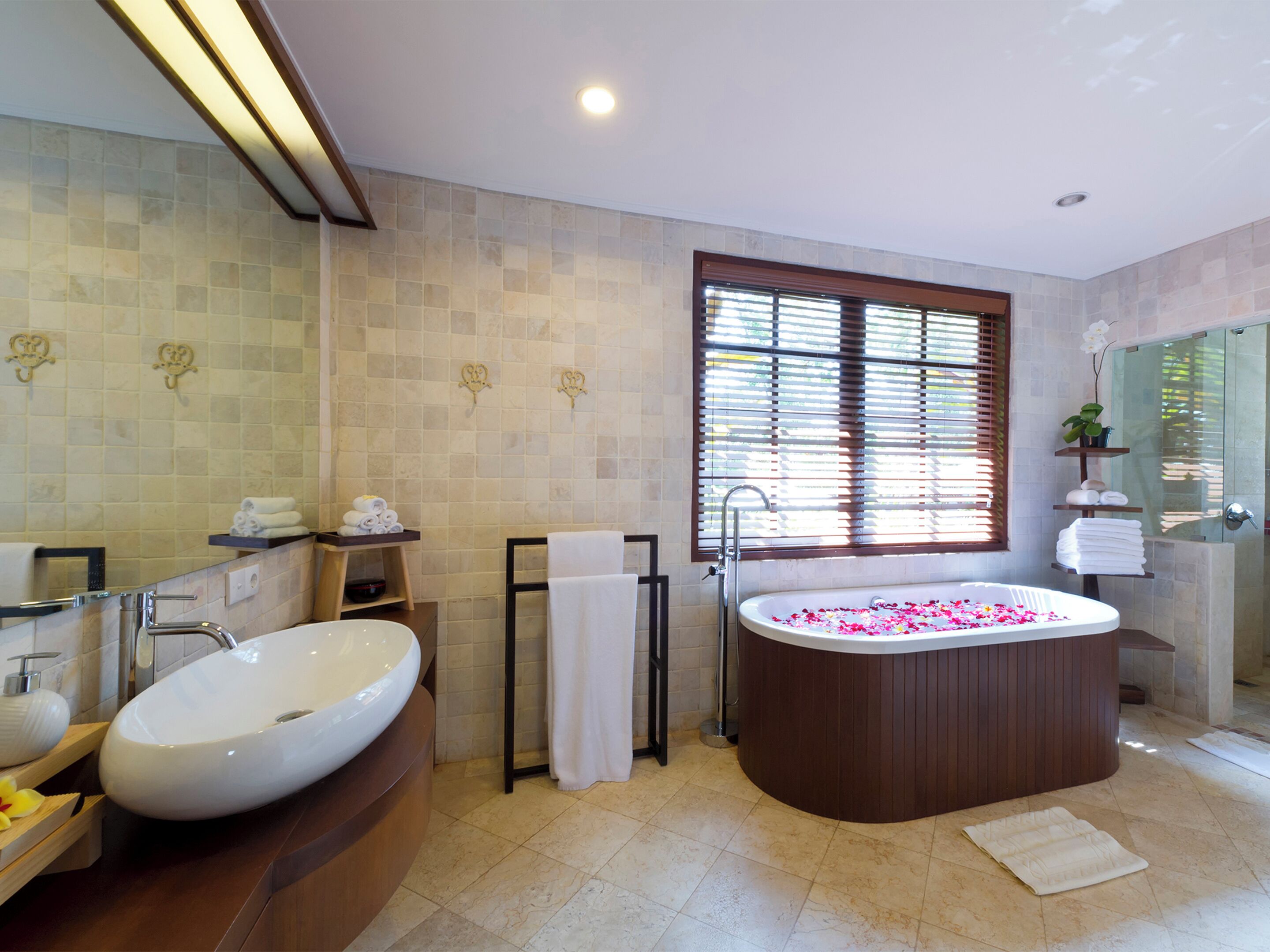 A modern bathroom with a large oval bathtub, a freestanding sink, and a walk-in shower.