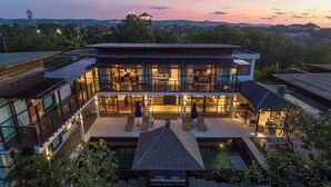 Una casa moderna de dos pisos con un amplio espacio exterior, ventanas grandes y vistas del paisaje circundante.