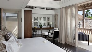 A modern bedroom with a large bed, a desk, and a balcony with a view. - Villa Adasa (Seminyak)