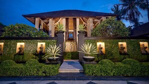 A modern building with a wooden structure, surrounded by well-maintained greenery and palm trees. - The Ylang Ylang (Blahbatuh)