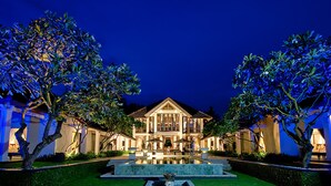 A large, well-lit hotel with a central courtyard, featuring a swimming pool and a sculpture. - The Ylang Ylang (Blahbatuh)