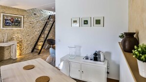 Eine moderne Küche mit einer Steinwand, einem weißen Schrank und einem Esstisch mit Kork-Untersetzern.