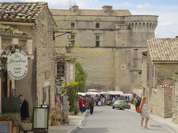 Una calle estrecha con edificios de piedra, un café y una boutique.