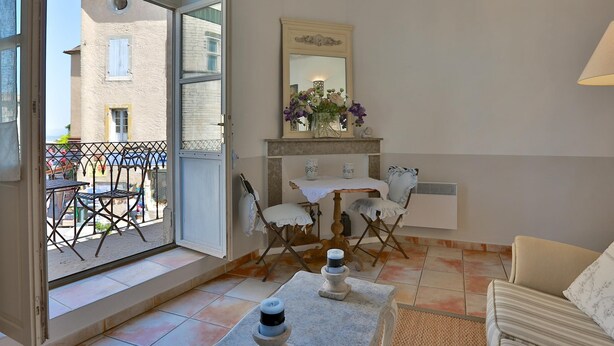 A room with a balcony, a dining table with chairs, a mirror, and a sofa. - Apartement Enjoy the Experience Gordes (Gordes)
