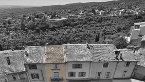 A courtyard with a building featuring a tiled roof and a ground floor with a shop named "Lobern Sochters". - Apartement Like a Local Gordes (Gordes)