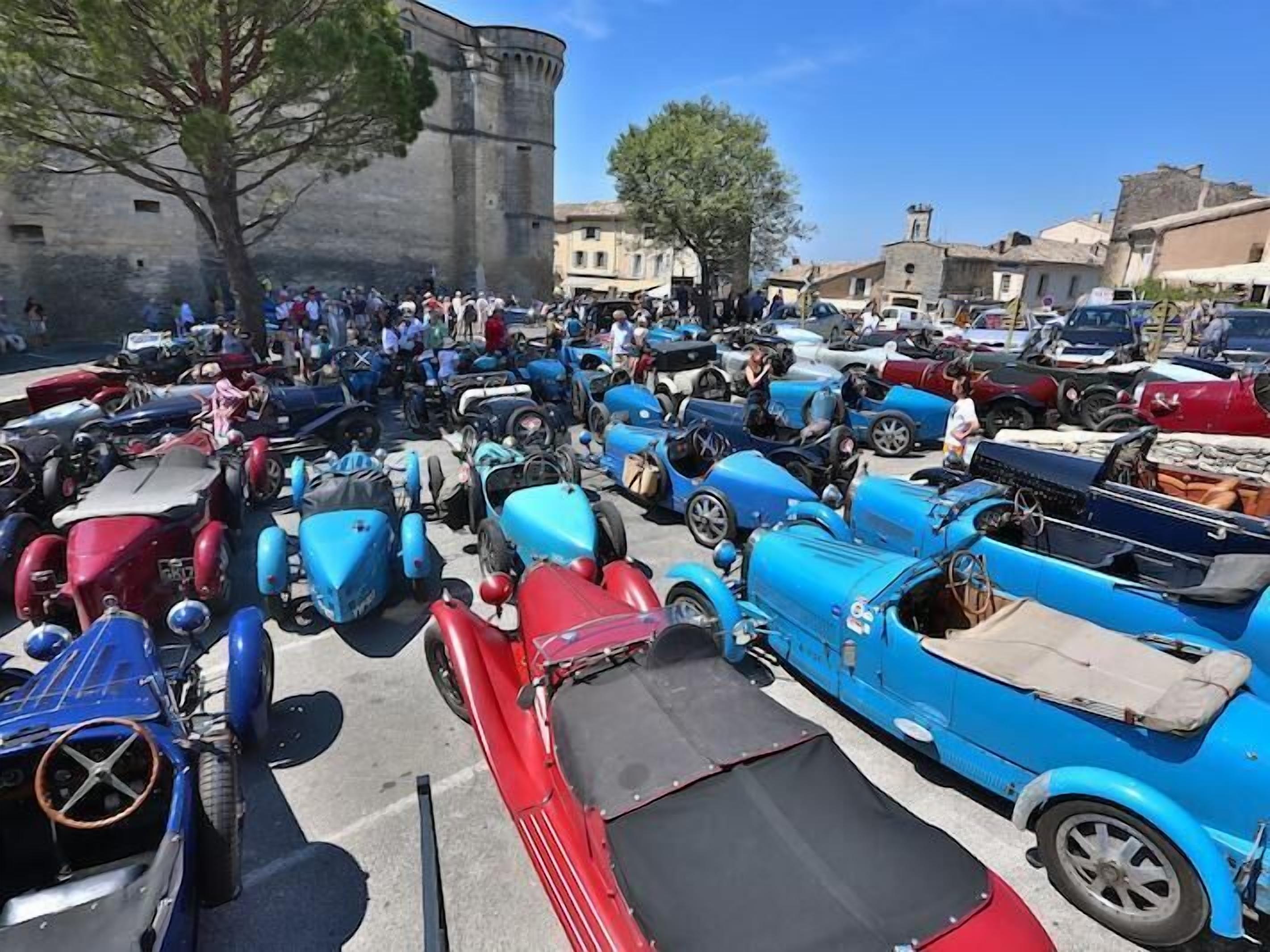 Un événement en plein air très fréquenté, où de nombreuses voitures anciennes sont exposées en rangées.