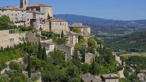 A historic town with stone buildings, a prominent tower, and a view of the surrounding countryside. - Apartement Like a Local Gordes (Gordes)