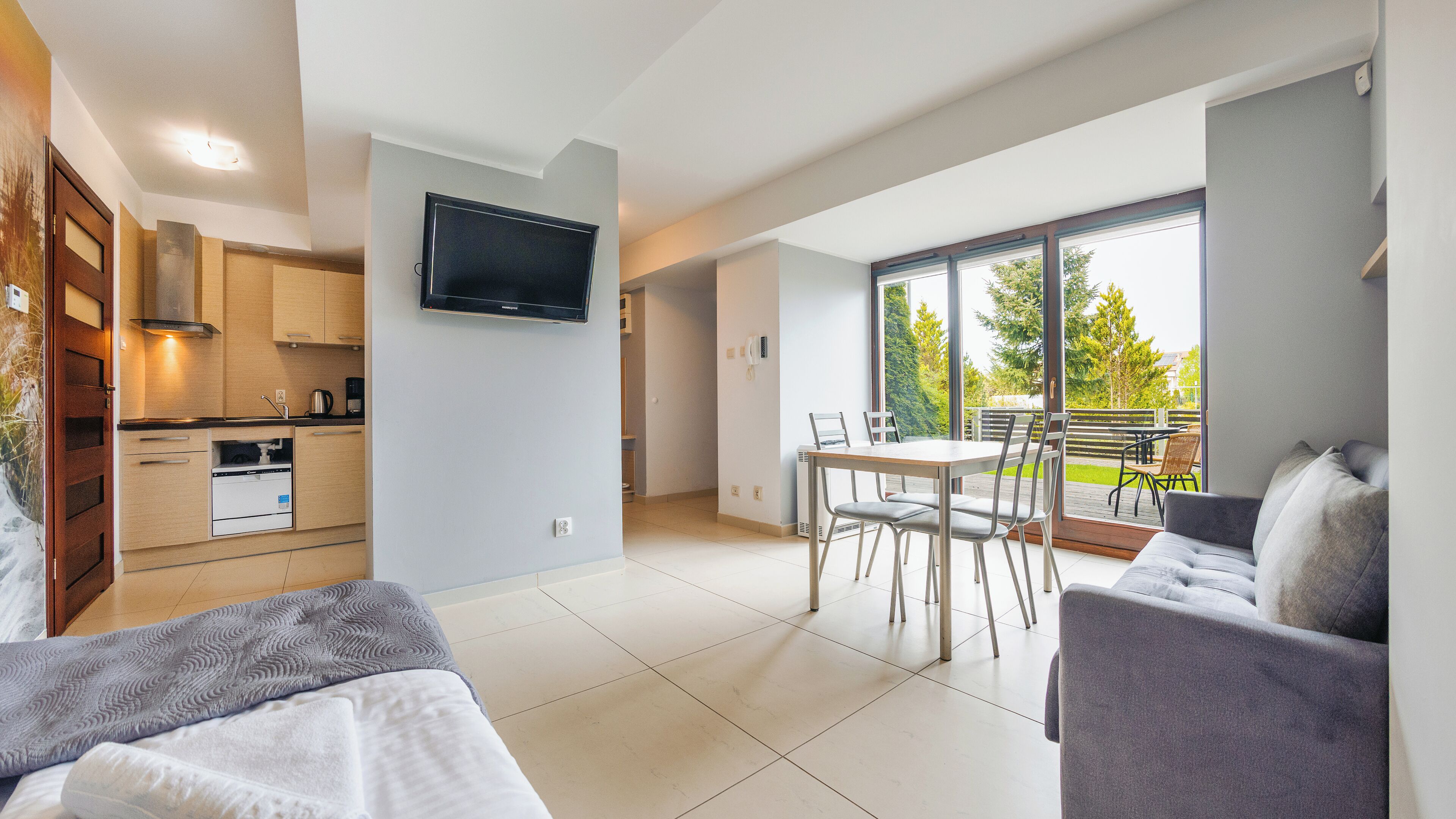 A modern apartment with a kitchen, dining area, and a balcony with a view.