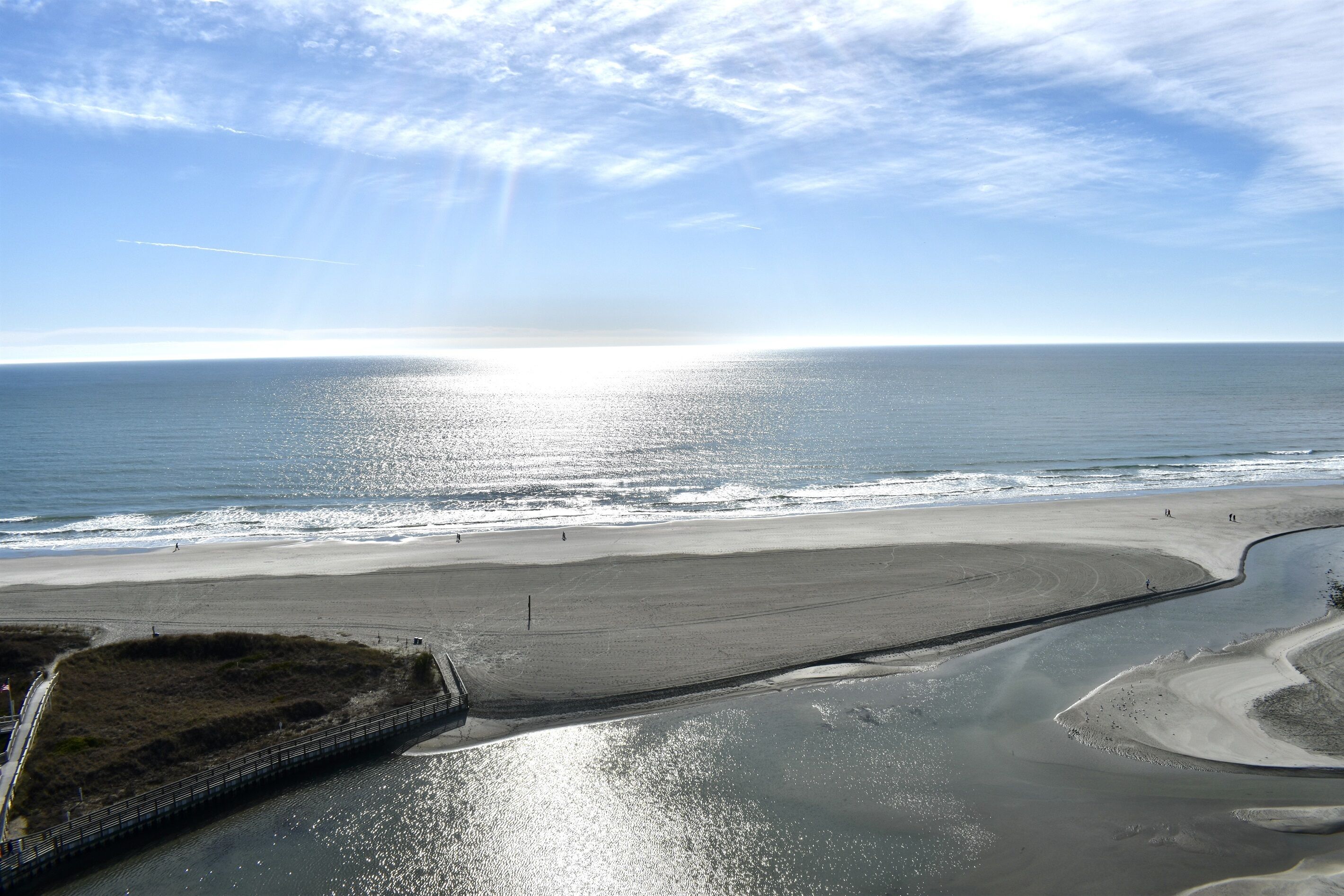 A coastal beach with a clear sky and a calm sea.