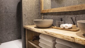 A modern bathroom with a large vessel sink, a wooden vanity, and a mirror. - Apartment FERRONNE by JAPANDI home (Megève)