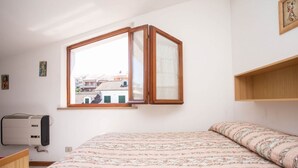 A bedroom with a bed, a window, a radiator, and a shelf. - M291 - Marcelli, apartment with terrace and reserved parking (Marcelli)
