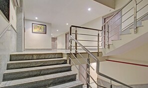 Una escalera con barandales de metal y peldaños de granito que conduce a una plataforma.