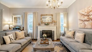 Un salon avec deux canapés, une cheminée et un lustre.