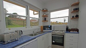 A modern kitchen with white cabinets, a blue countertop, a built-in oven, a microwave, and a toaster. - Superb new cottage, stunning views, secluded but handy to Hahndorf Main Street (Hahndorf)