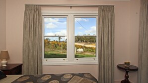 A hotel room with a bed, a window with curtains, a bedside table with a lamp, and a small round table with a bowl. - Superb new cottage, stunning views, secluded but handy to Hahndorf Main Street (Hahndorf)