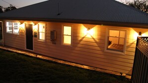A single-story house with a sloped roof, multiple windows, and exterior lighting. - Superb new cottage, stunning views, secluded but handy to Hahndorf Main Street (Hahndorf)