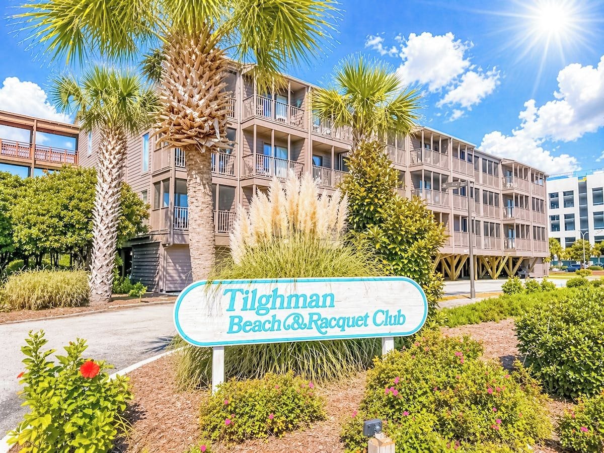 A sign for the Tilghman Beach & Racquet Club with a multi-story building in the background.
