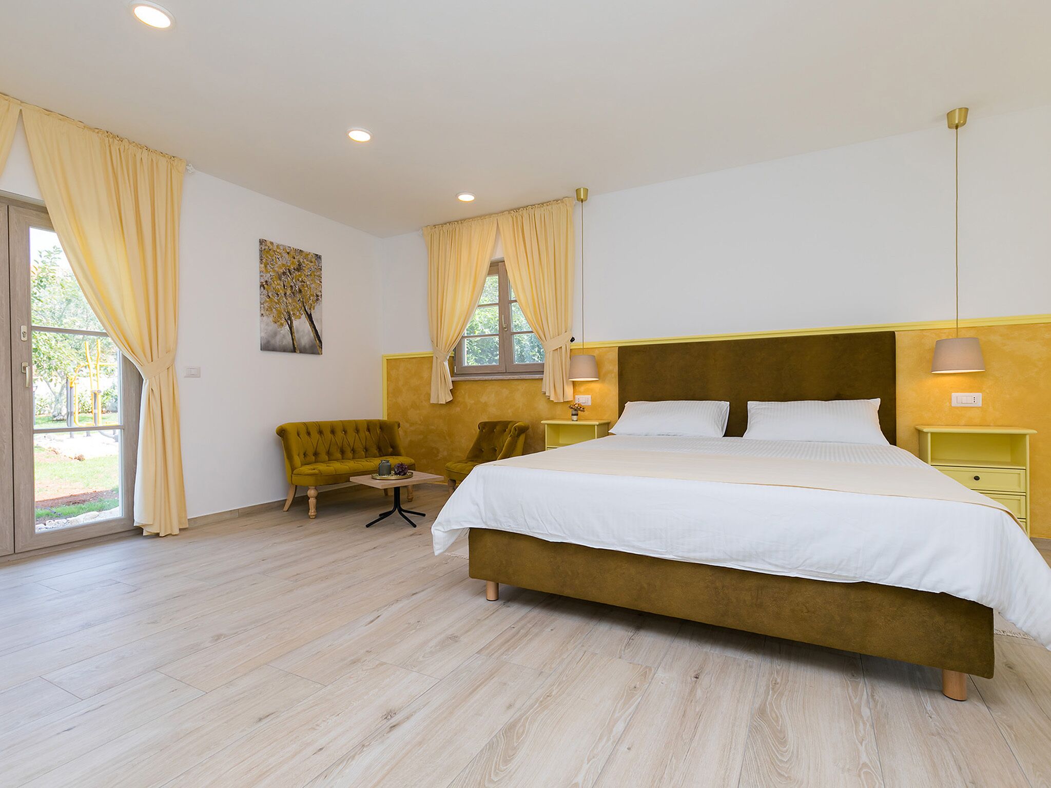 A hotel room with a large bed, two bedside tables, a chair, and a window with curtains.