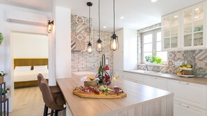 A modern kitchen with a central island, hanging pendant lights, and a breakfast bar.