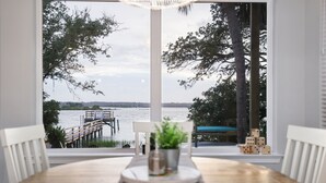 A dining table with a view of a lake and dock. - Gorgeous Waterfront w/ Golf Cart! 4 bds, 3.5 ba! Sleeps 12 (St. Augustine)