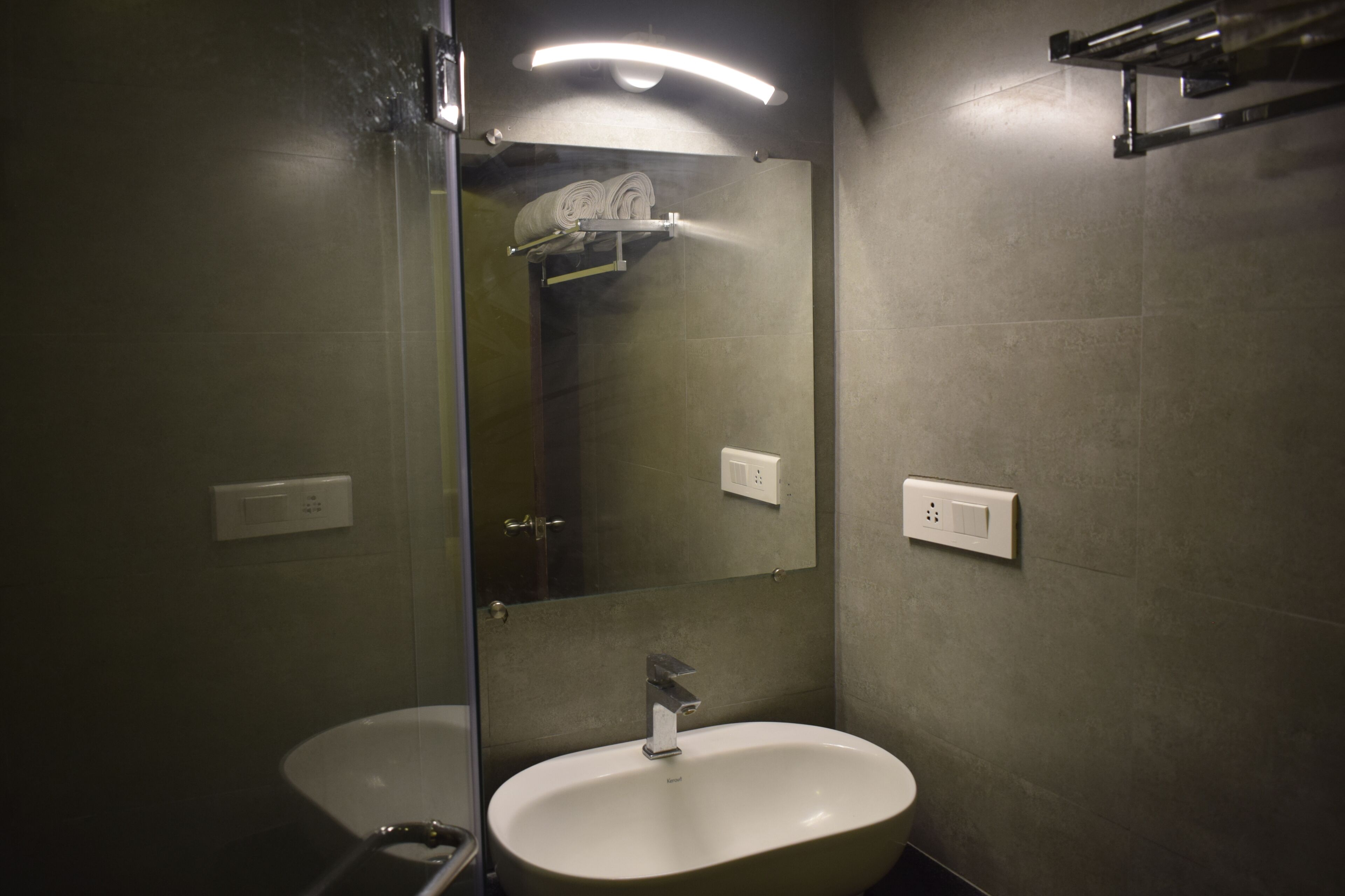A bathroom with a sink, a mirror, and a towel rack.