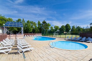 Una piscina cubierta, una piscina al aire libre de temporada, sombrillas