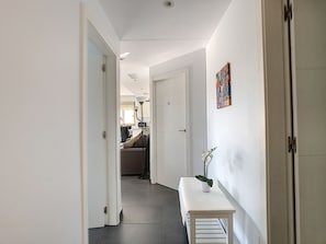 Ein Flur mit einer Bank, einer Tür und einer Wand mit einem farbenfrohen Kunstwerk.