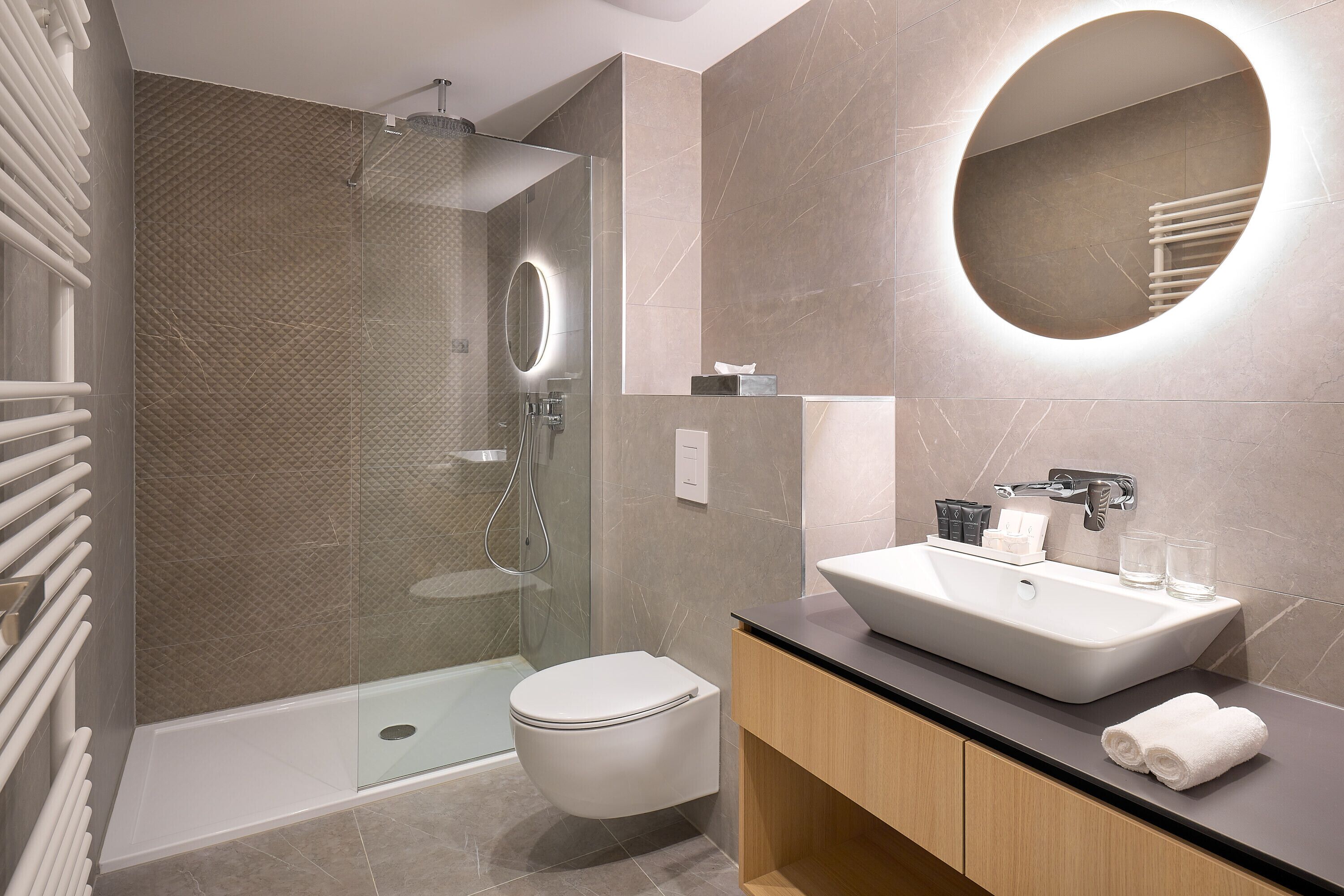 A modern bathroom with a glass-enclosed shower, a white toilet, and a vanity with a sink and mirror.