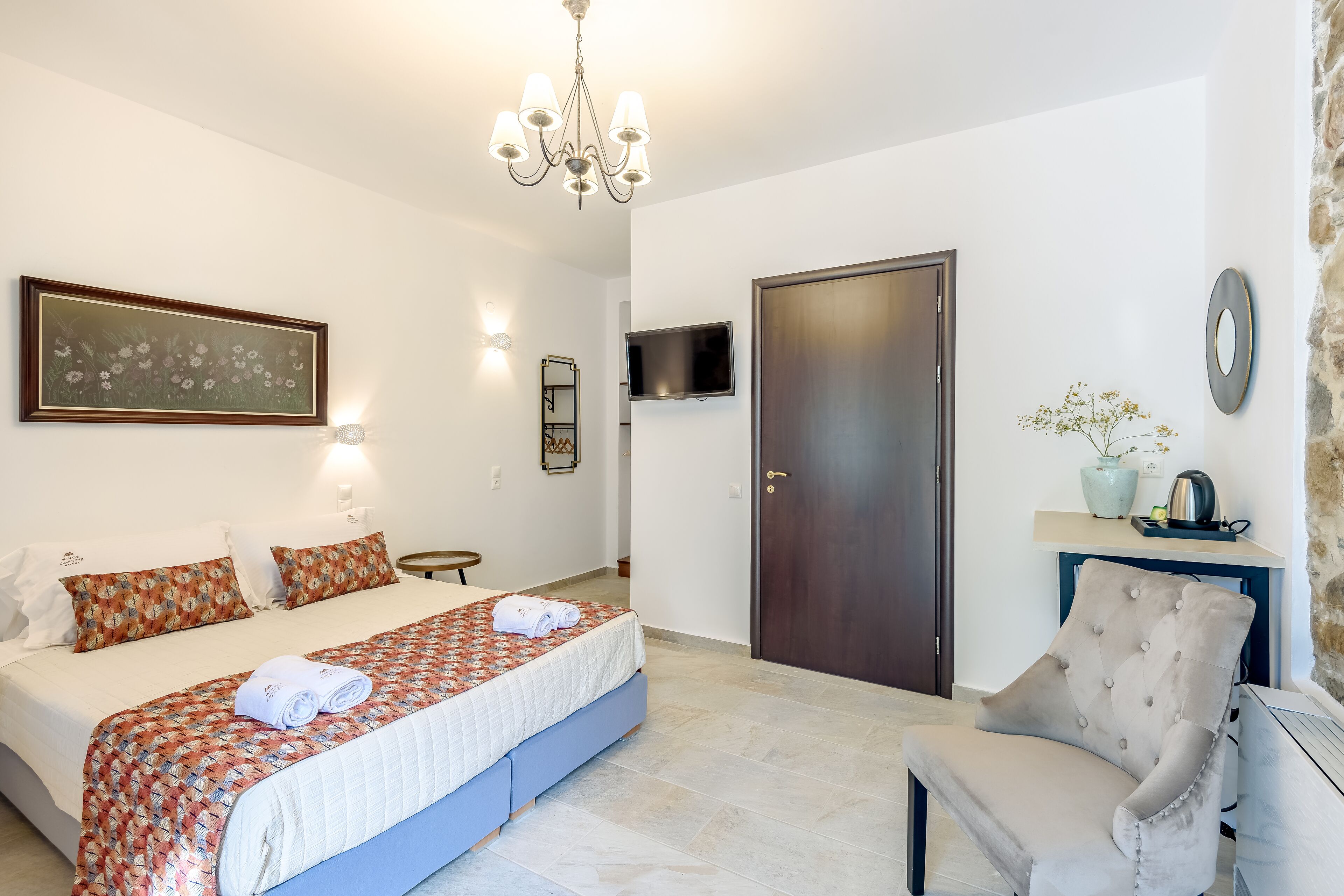 A neatly arranged bedroom with a bed, bedside table, and a chair.