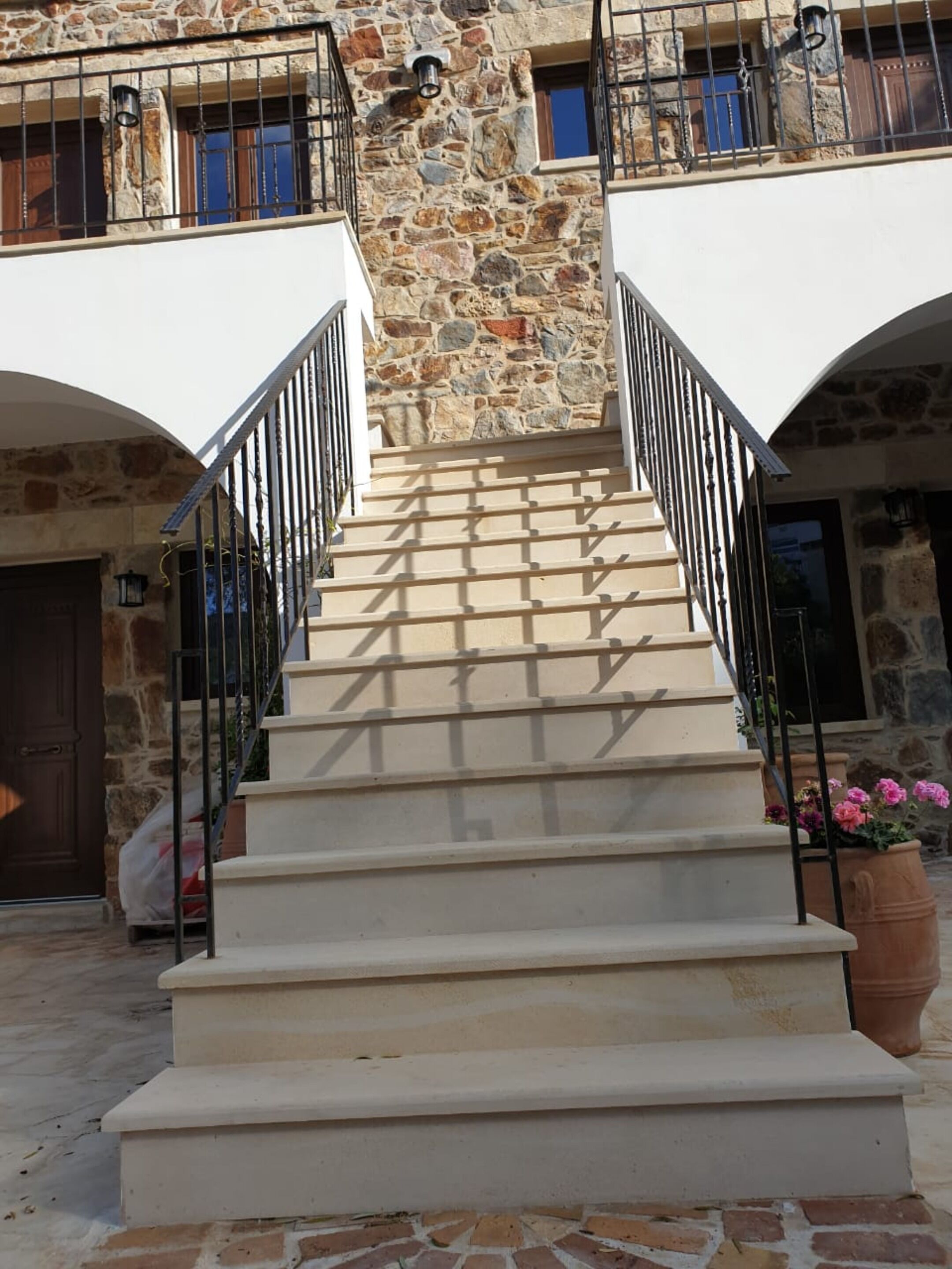 A stone building with a staircase leading to a second floor.