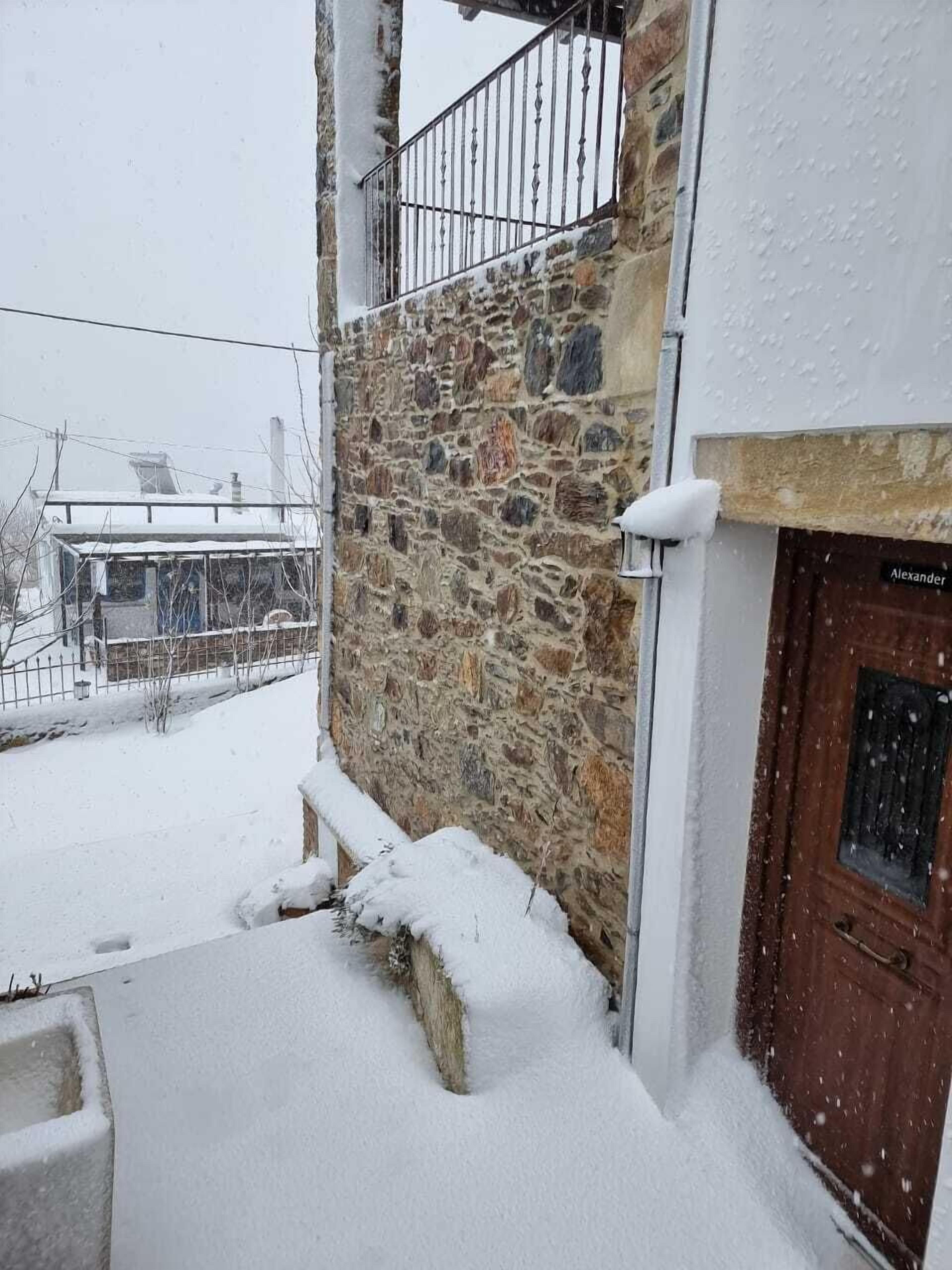 A stone building with a wooden door labeled "Alexander".