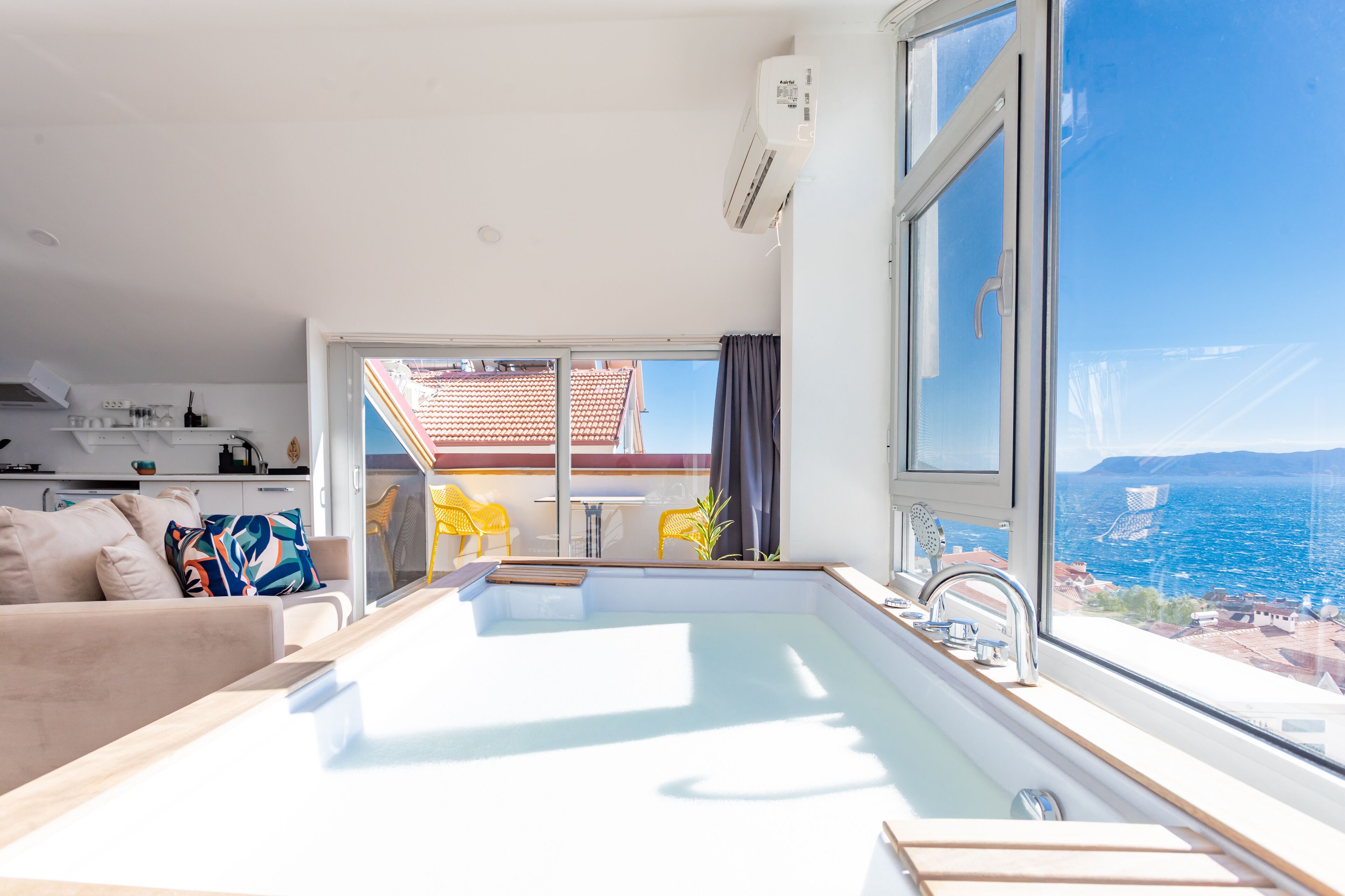 Un apartamento moderno con balcón, una zona de cocina y vistas al mar.