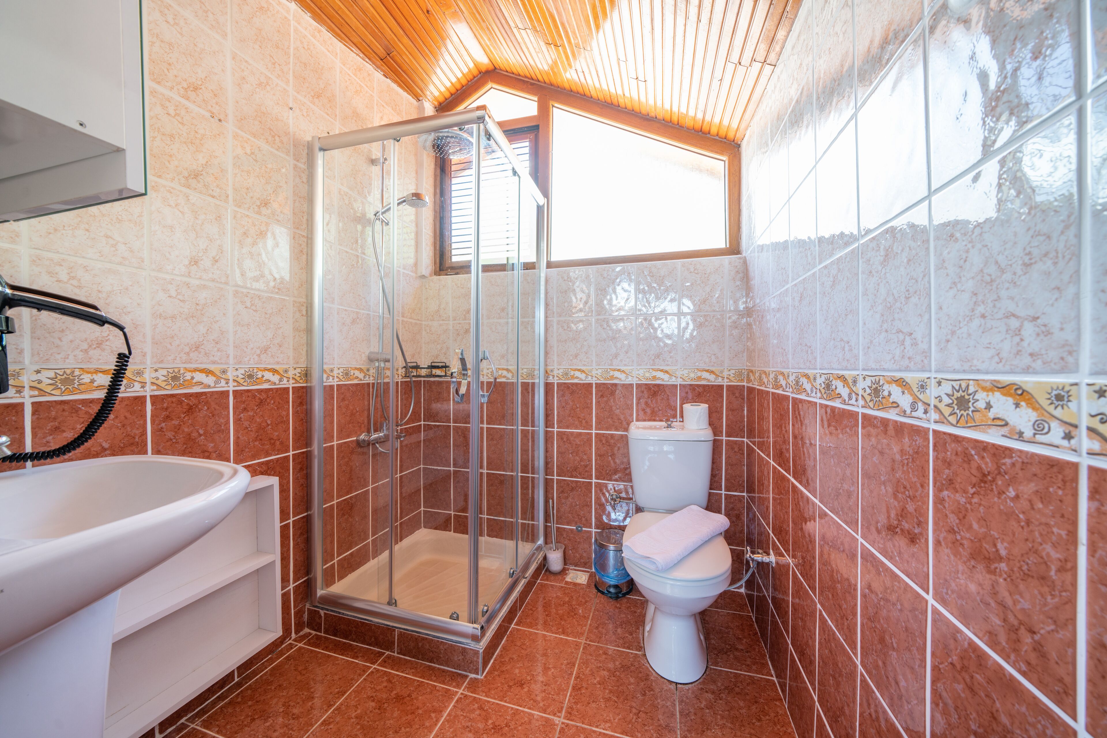 A bathroom with a shower, toilet, and sink.