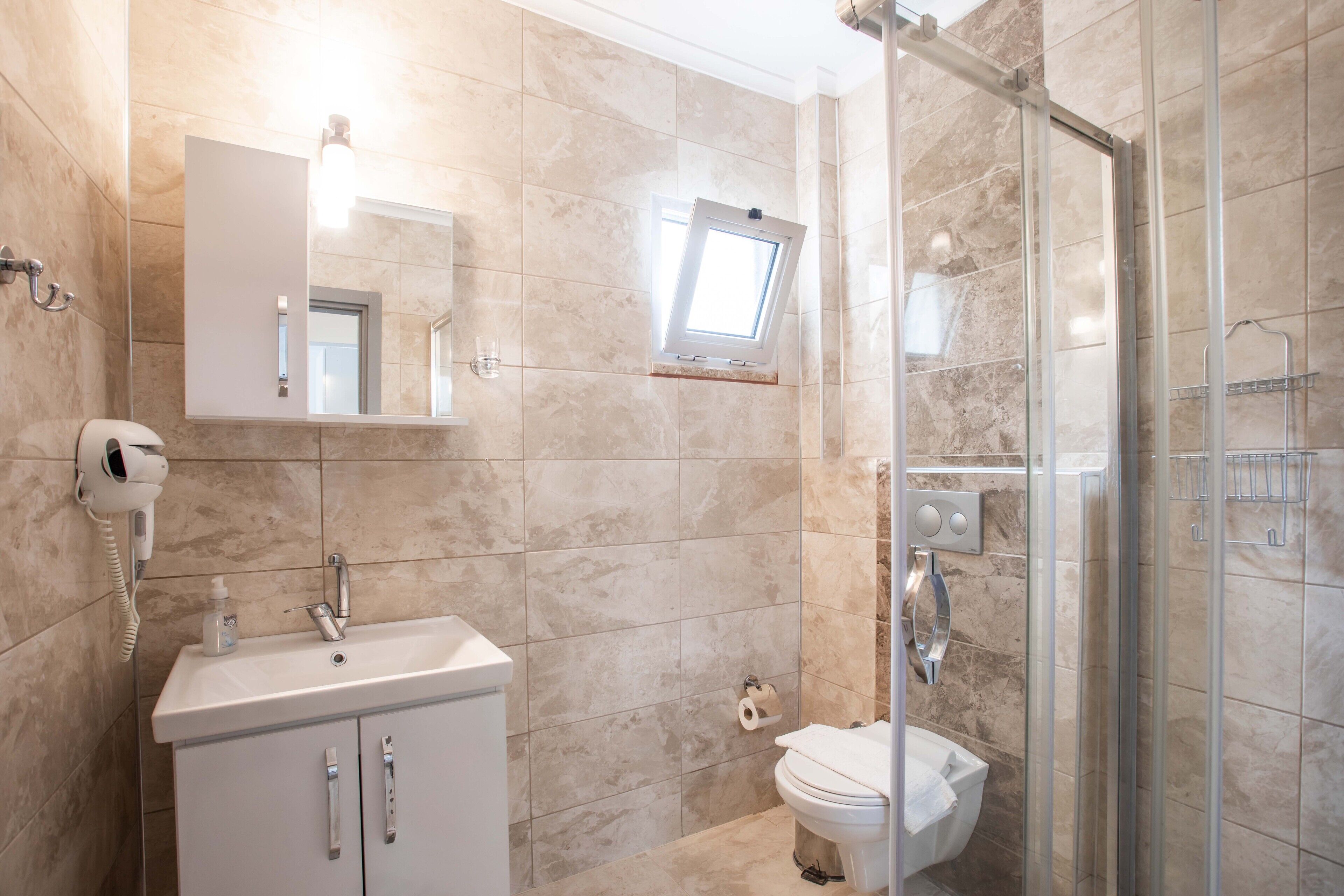A bathroom with a sink, mirror, and toilet.
