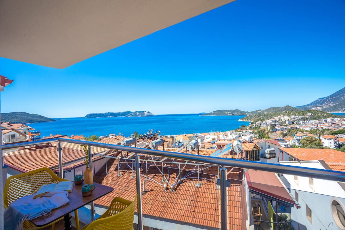 Een balkon met uitzicht op zee en een stad.