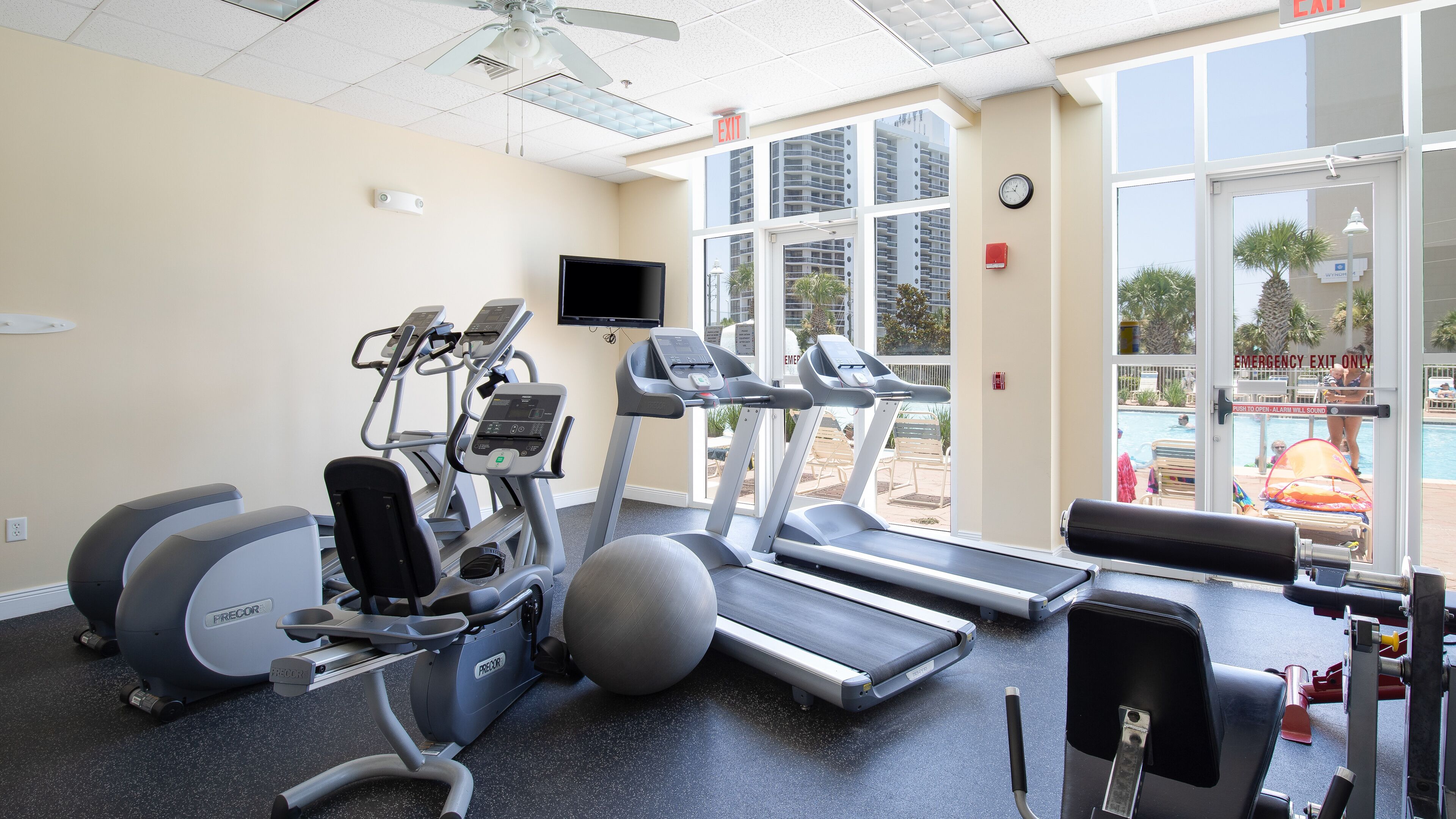 A gym with treadmills, elliptical machines, and a stationary bike.