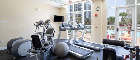 A gym with treadmills, elliptical machines, and a stationary bike.